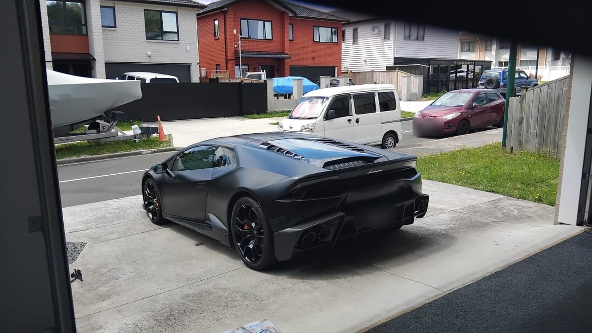 Matte black Lamborghini Huracán parked on a client driveway after a detail