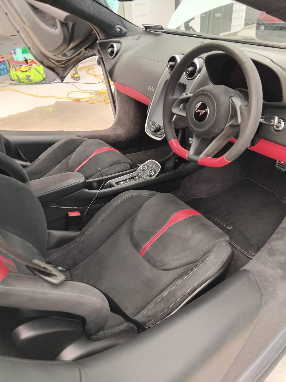 McLaren cabin with black Alcantara and red trim, cleaned and dressed
